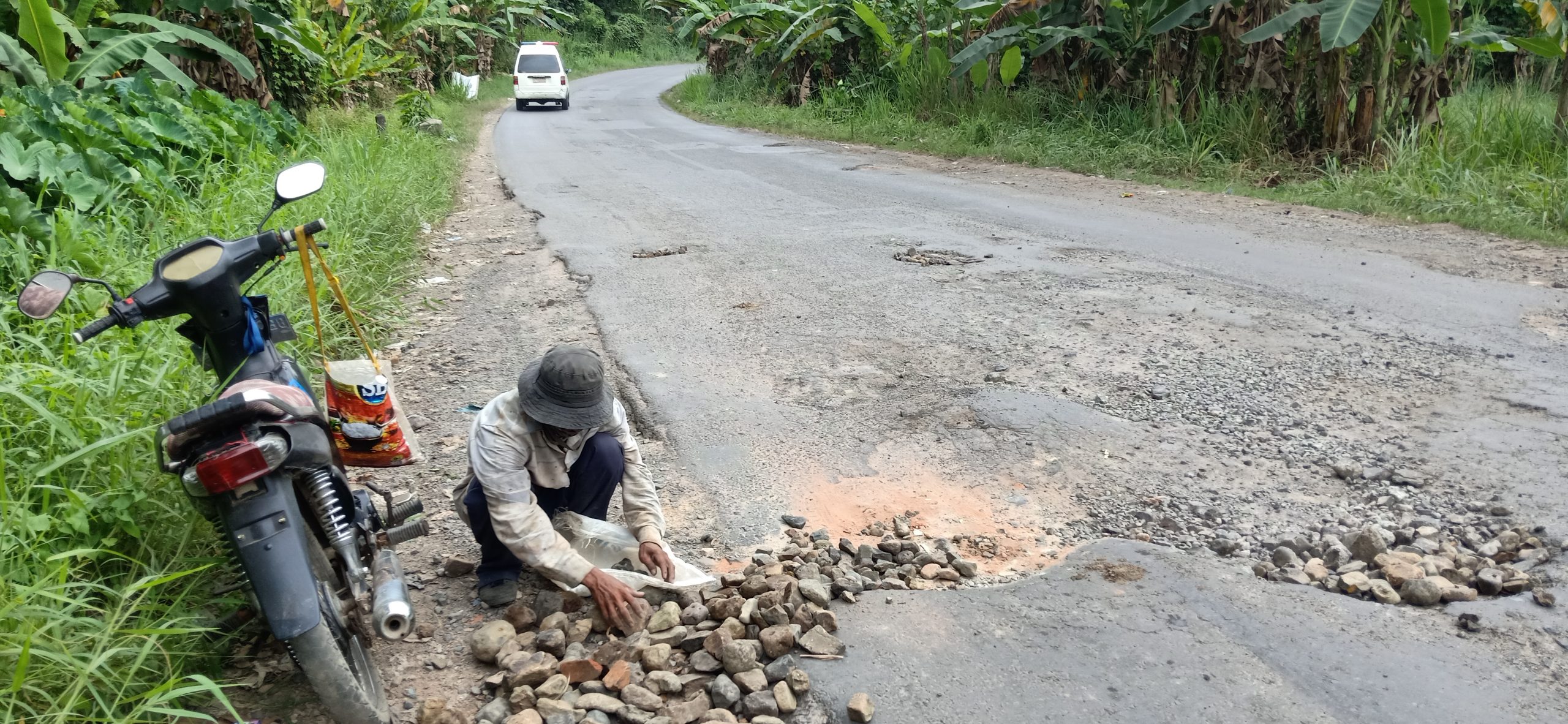 Prihatin Dengan Kondisi Jalan, Pria Paruh Baya Sukarela Timbun Jalan Berlubang